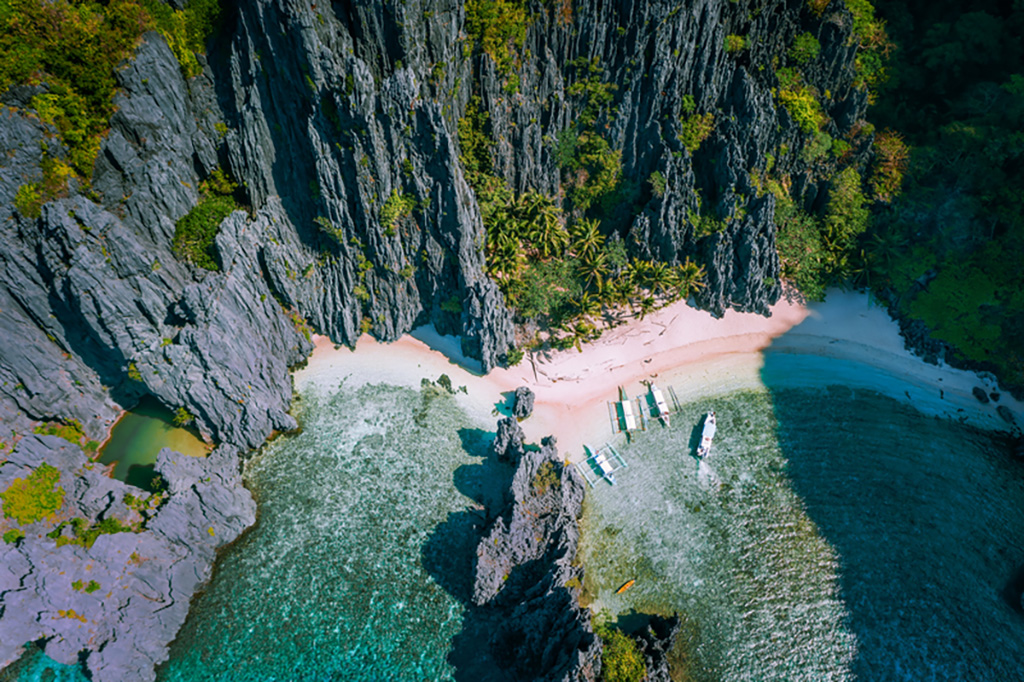 Aerial view of Secret hidden lagoon beach with tourist banca boats. Best Summer Destinations in Philippines